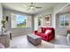 Cozy bonus living room with red sofa, ottoman, plantation shutters, and a ceiling fan at 12170 Lake Allen Dr, Largo, FL 33773