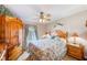 Charming bedroom featuring a decorative ceiling fan, a window with curtains, and warm wood furniture at 12501 Ulmerton Rd # 14, Largo, FL 33774