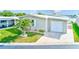 Charming home featuring a well-manicured lawn, a palm tree, a brick-paved driveway, and an attached garage at 12501 Ulmerton Rd # 14, Largo, FL 33774