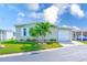 Charming home featuring a well-manicured lawn, lush palms, and an attached garage at 12501 Ulmerton Rd # 14, Largo, FL 33774