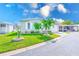 Charming home with well-manicured lawn, a carport, and neatly trimmed palm trees, offering great curb appeal at 12501 Ulmerton Rd # 14, Largo, FL 33774