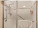 Bright, white tiled shower with glass doors and safety handrails, offering accessibility and a clean aesthetic at 12501 Ulmerton Rd # 14, Largo, FL 33774