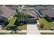 Aerial view of a home with a well-manicured front lawn and a driveway, in a residential neighborhood at 12618 Sandpine Reserve Pl, Gibsonton, FL 33534