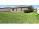 Well-maintained backyard with lush green grass, a privacy fence, and a view of the home's exterior at 12618 Sandpine Reserve Pl, Gibsonton, FL 33534
