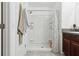 Bright bathroom featuring a shower with a white tile surround and dark vanity with a granite countertop at 12618 Sandpine Reserve Pl, Gibsonton, FL 33534