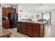 Spacious kitchen features island with sink, dark wood cabinets, and modern black appliances at 12618 Sandpine Reserve Pl, Gibsonton, FL 33534
