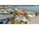 Inviting yellow waterfront home features a metal roof, a 2-car garage, a waterfront dock, and lush landscaping at 13514 Garris Dr, Hudson, FL 34667
