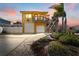 Charming yellow two-story home with lush landscaping, palm trees, and a two-car garage at 13514 Garris Dr, Hudson, FL 34667