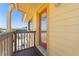 Front door entrance from the balcony of this charming yellow two-story home at 13514 Garris Dr, Hudson, FL 34667