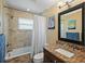 Bathroom with granite countertops, shower over tub, and tiled walls at 1361 46Th Ne Ave, St Petersburg, FL 33703