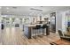Modern kitchen features a large island, stainless steel appliances, custom cabinetry, and stylish pendant lighting, adjacent to living area at 1361 46Th Ne Ave, St Petersburg, FL 33703