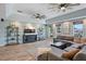 Inviting living room featuring wood-look flooring, an oversized sectional, media center, and a cozy atmosphere, perfect for relaxation at 1361 46Th Ne Ave, St Petersburg, FL 33703