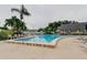 Inviting community pool with lounge chairs, tables, and lush landscaping at 14130 Rosemary Ln # 3312, Largo, FL 33774
