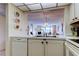 Bright kitchen features double sinks, white cabinetry, and an open layout into the living area at 14130 Rosemary Ln # 3312, Largo, FL 33774