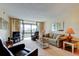 Bright living room with comfortable seating, neutral colors, and sliding glass doors to balcony at 14130 Rosemary Ln # 3312, Largo, FL 33774