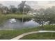Serene pond view showcasing a fountain, palm trees, and lush landscaping creating a tropical oasis at 14130 Rosemary Ln # 3312, Largo, FL 33774