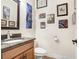 Powder room features a granite vanity, decorative mirror, and multiple framed wall art pieces at 15723 Starling Water Dr, Lithia, FL 33547