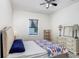 Comfortable bedroom with ceiling fan features a dresser, mirror, and a patterned bedspread at 15723 Starling Water Dr, Lithia, FL 33547
