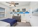 Bedroom with blue accents features three windows, ceiling fan, dresser, and carpet flooring at 15723 Starling Water Dr, Lithia, FL 33547