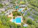 Aerial view of community featuring pools, waterpark, clubhouse, green spaces, parking, and beautiful landscaping at 15723 Starling Water Dr, Lithia, FL 33547