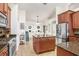 Open kitchen view showcasing an island, stainless steel refrigerator, and dining area beyond at 15723 Starling Water Dr, Lithia, FL 33547