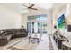 Bright living room features vaulted ceilings, large windows, and an elegant ceiling fan at 15723 Starling Water Dr, Lithia, FL 33547