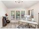 Well-lit office space featuring a modern desk, views of the outdoors, and wood laminate flooring at 15723 Starling Water Dr, Lithia, FL 33547