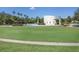 View of the community park featuring manicured lawn, palm trees, and a walking trail with shops in the background at 15723 Starling Water Dr, Lithia, FL 33547