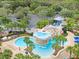Aerial view of community waterpark featuring pool, waterfall, slide, gazebo, lounge seating, and palm trees at 15723 Starling Water Dr, Lithia, FL 33547