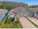 Charming single-Gathering home featuring a paved driveway, a two-car garage and lush landscaping at 16822 Balance Cv, Land O Lakes, FL 34638