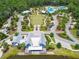 Aerial view of the community center with blue siding, a lake view, and walking paths throughout at 16822 Balance Cv, Land O Lakes, FL 34638