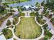 Aerial view of the community center with walking paths, a green, and ample parking spaces at 16822 Balance Cv, Land O Lakes, FL 34638