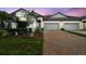 Charming townhome featuring a brick driveway, manicured lawn, and two-car garage at 16822 Balance Cv, Land O Lakes, FL 34638