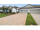 Attractive townhome with a brick driveway, lush lawn, and two-car garage at 16822 Balance Cv, Land O Lakes, FL 34638