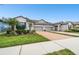 Well-maintained townhome showcasing a brick driveway, manicured lawn, and two-car garage at 16822 Balance Cv, Land O Lakes, FL 34638