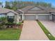 Lovely home exterior with a brick driveway, two-car garage, and well-kept landscaping at 16822 Balance Cv, Land O Lakes, FL 34638