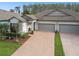 Beautiful exterior of the home featuring a well-manicured lawn, brick driveway, and a two-car garage at 16822 Balance Cv, Land O Lakes, FL 34638