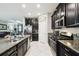 Modern kitchen with stainless steel appliances, granite countertops, and stylish dark cabinets for a chic look at 16822 Balance Cv, Land O Lakes, FL 34638