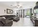 Spacious living room with a leather sectional, tile flooring, and access to the outdoor patio at 16822 Balance Cv, Land O Lakes, FL 34638
