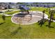 A fun playground for children with swings, a slide, and covered play area surrounded by green space at 16822 Balance Cv, Land O Lakes, FL 34638