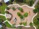 Aerial view of a community playground with a fire pit, wooden play structure, and landscaping at 16822 Balance Cv, Land O Lakes, FL 34638