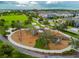 Aerial view of a community playground with slides, swings, climbing structures, and mature trees at 16822 Balance Cv, Land O Lakes, FL 34638