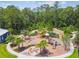Aerial view of the neighborhood playground with seating, landscaping, and a firepit at 16822 Balance Cv, Land O Lakes, FL 34638
