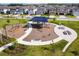 Community playground featuring swings, a slide, benches, and shade, all surrounded by lush landscaping at 16822 Balance Cv, Land O Lakes, FL 34638