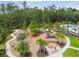 Aerial view of a playground featuring a wooden playset, a fire pit with Adirondack chairs, and landscaped walkways at 16822 Balance Cv, Land O Lakes, FL 34638