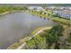 Scenic view of a pond with a walking path alongside apartments and townhomes at 16822 Balance Cv, Land O Lakes, FL 34638