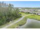 Pondside view of homes along a community walking path, with a view of the lake at 16822 Balance Cv, Land O Lakes, FL 34638