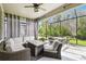 Relaxing screened patio with comfortable seating, ceiling fan, and a view of the lush greenery at 16822 Balance Cv, Land O Lakes, FL 34638