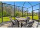 Enjoy the outdoors in this screened-in patio with table, chairs, and a view of the green lawn at 16822 Balance Cv, Land O Lakes, FL 34638