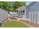 Backyard featuring a sunroom extension, decorative paver patio, and private fencing at 1700 Hunter Ln, Tarpon Springs, FL 34689